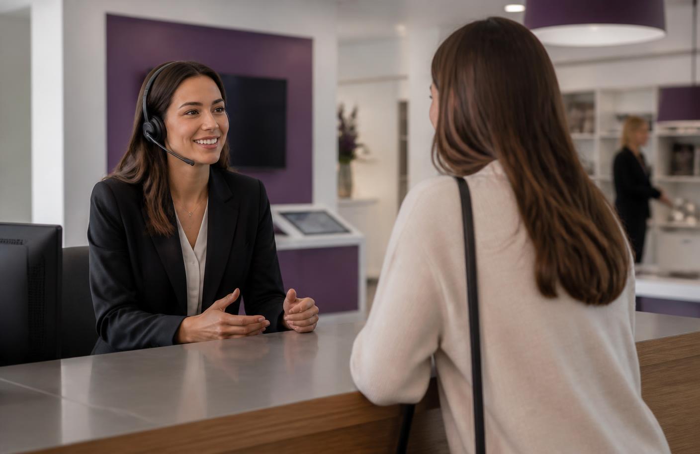 A customer service adviser talking with a customer at a reception desk